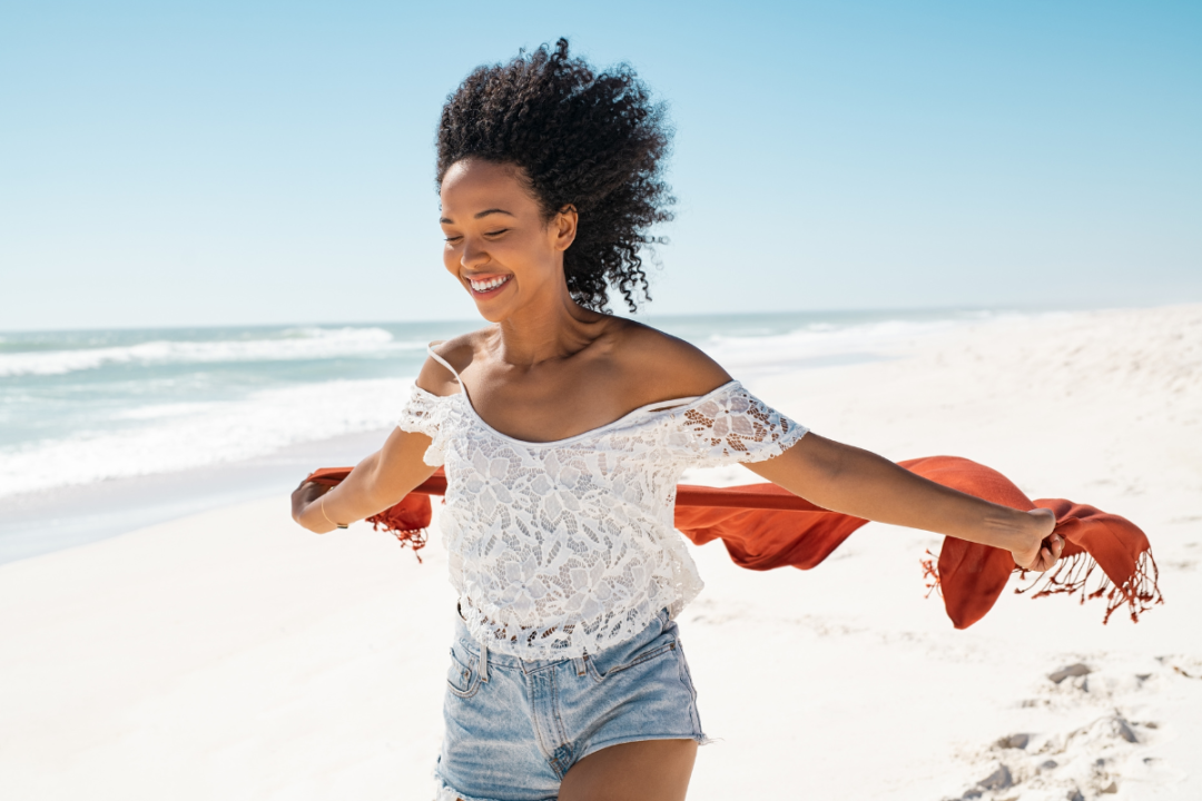 Woman on a beach, full of joy